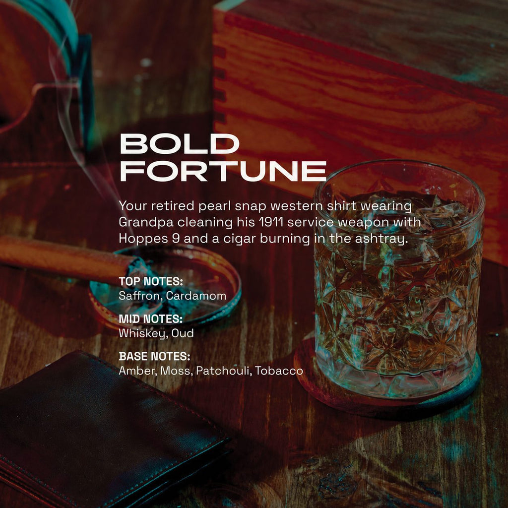 Bold Fortune fragrance graphic showing a leather wallet, cigar resting in an ashtray, whiskey glass, and wooden box on a dark wood table. Text describes the scent as a rugged, smoky blend with notes of saffron, cardamom, whiskey, oud, amber, moss, patchouli, and tobacco.