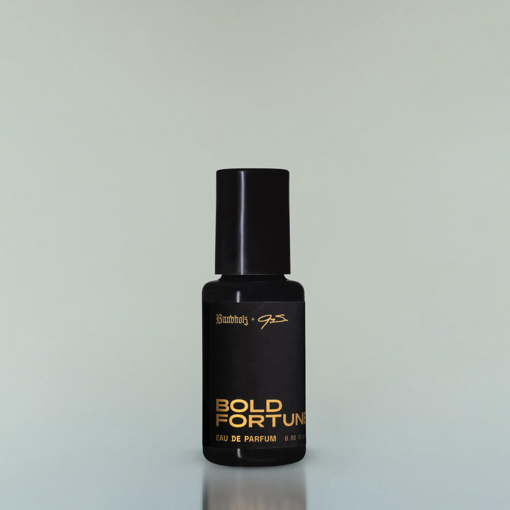 A bottle of Bold Fortune Eau de Parfum against a grey background.