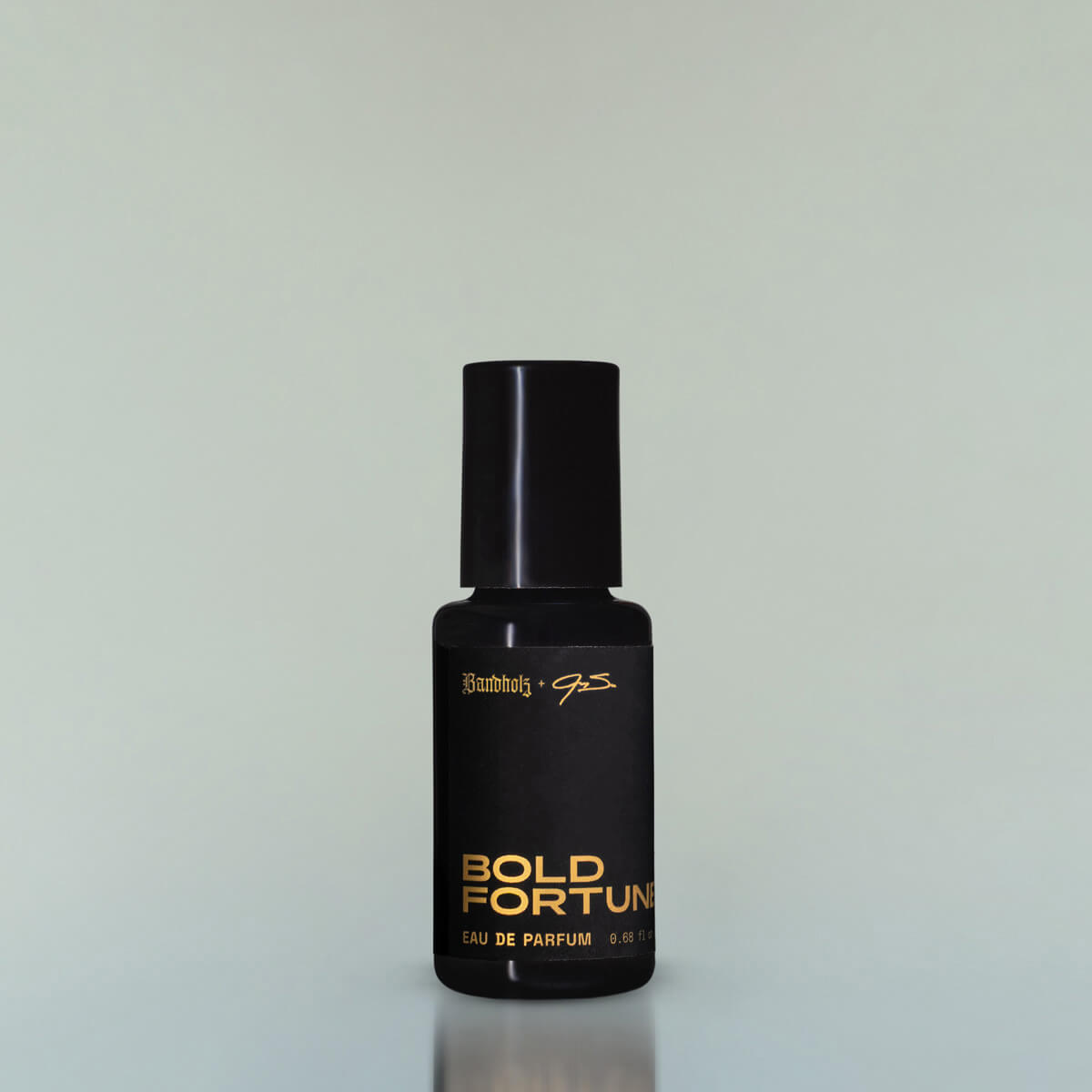 A bottle of Bold Fortune Eau de Parfum against a grey background.