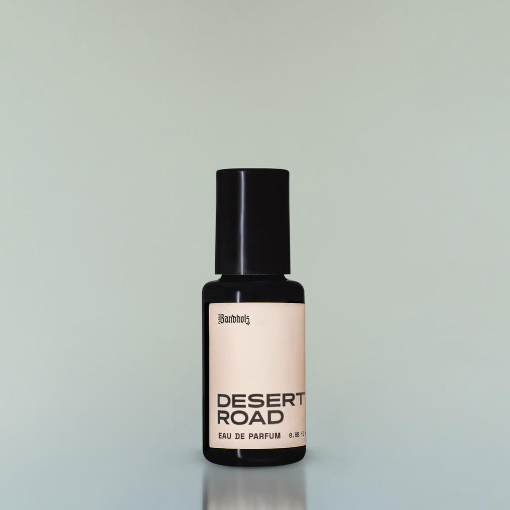 A bottle of Desert Road Eau de Parfum against a grey background.
