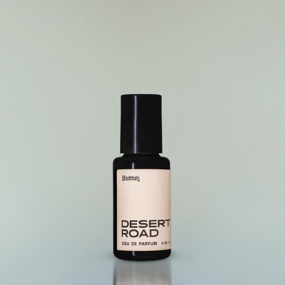 A bottle of Desert Road Eau de Parfum against a grey background.