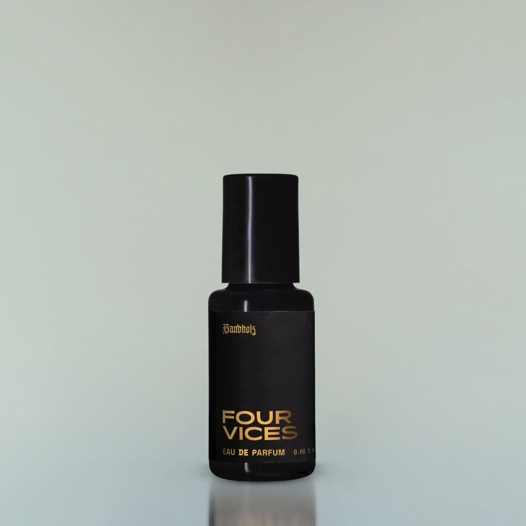 A bottle of Four Vices Eau de Parfum against a grey background.