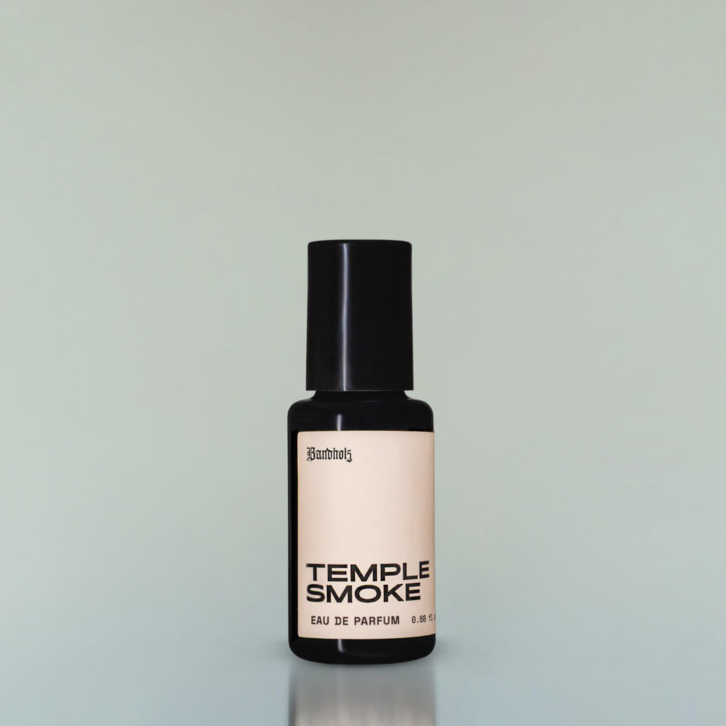 A bottle of Temple Smoke Eau de Parfum against a grey background.