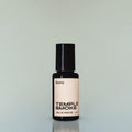 A bottle of Temple Smoke Eau de Parfum against a grey background.