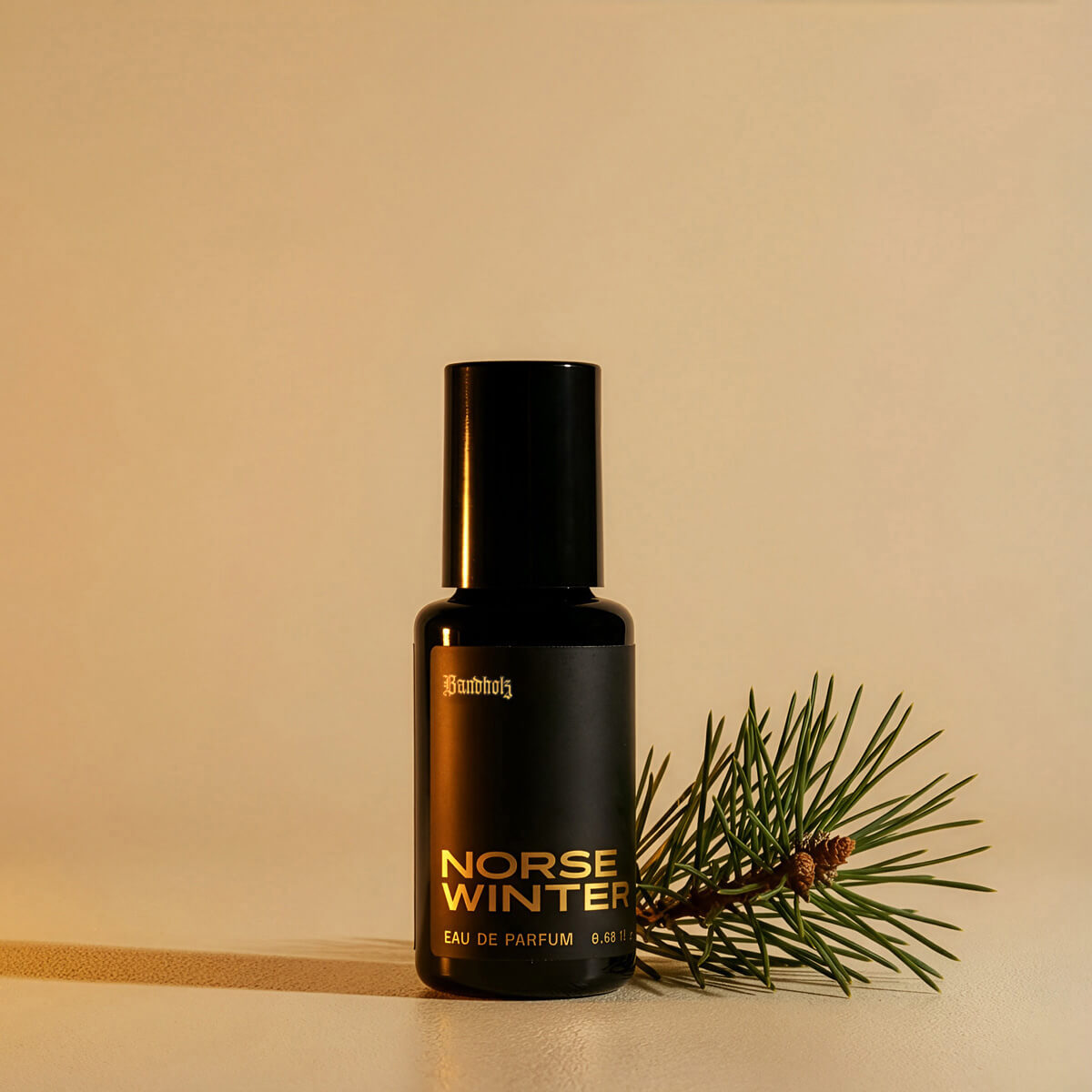 Bandholz Norse Winter Eau de Parfum bottle with pine branch and cones symbolizing the fragrance’s crisp evergreen and winter forest scent.
